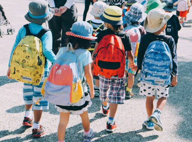 通学路を歩く子どもたちの後ろ姿を示すイメージ写真