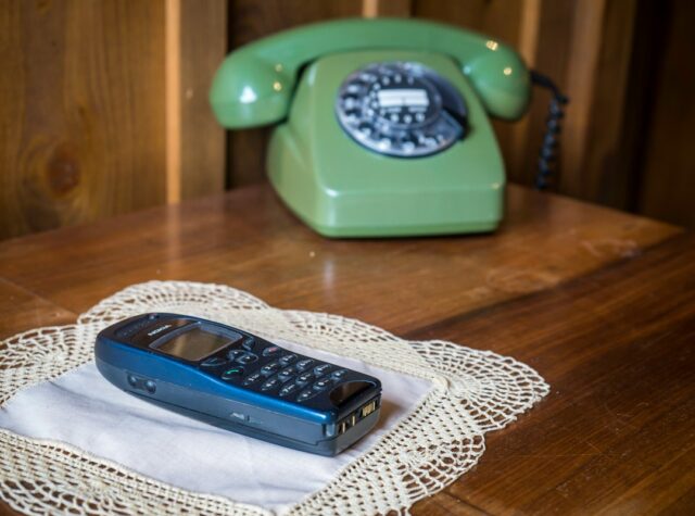 固定電話とスマートフォンを並べたイメージ写真